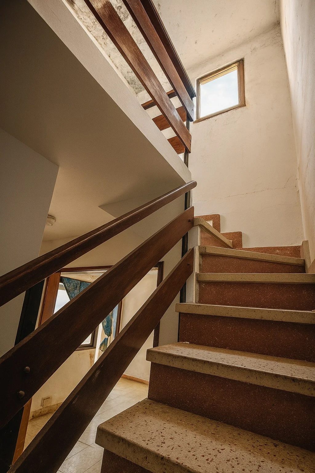 Escalera interior con barandilla de madera.